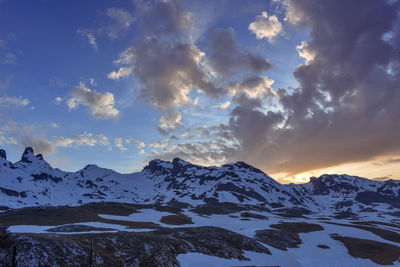 Scenic view of snowcapped mountains against sky during sunset