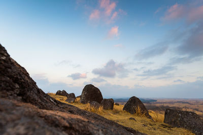 Rock formations on landscape against sky during sunset