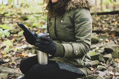 Midsection of woman holding smart phone