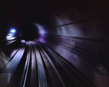 Railroad tracks in illuminated tunnel