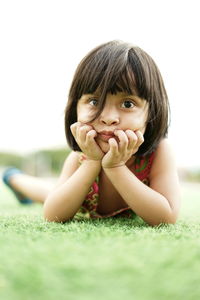 Portrait of girl lying on land at park