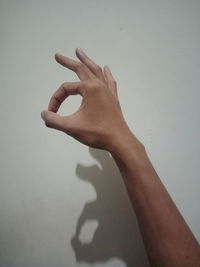 Cropped image of hand against wall