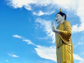 Low angle view of buddha statue against sky