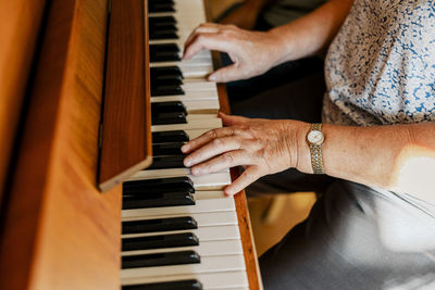 High angle view of senior woman playing piano at home