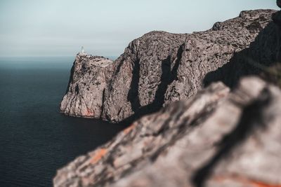 Rock formations by sea against sky