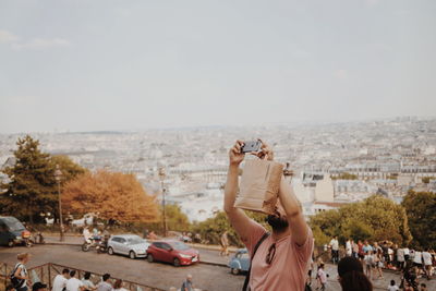 People on road against sky in city