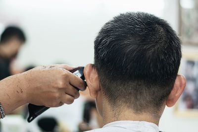 Close-up of man getting haircut