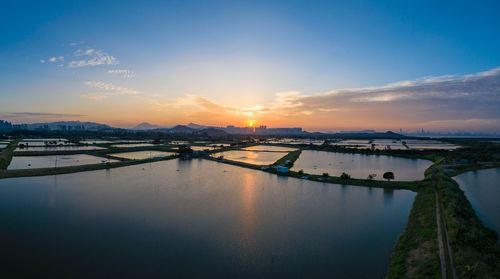 Bridge over river against sky during sunset