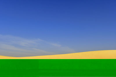 Scenic view of field against blue sky