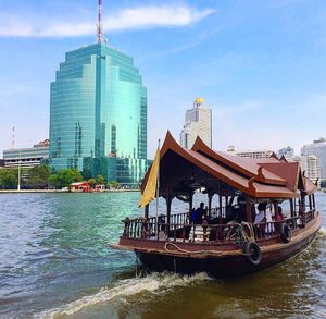 Boat in city against sky