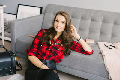 Young beautiful european makeup artist records a review of a cosmetic product, sitting among makeup