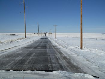 Snow covered road against clear sky