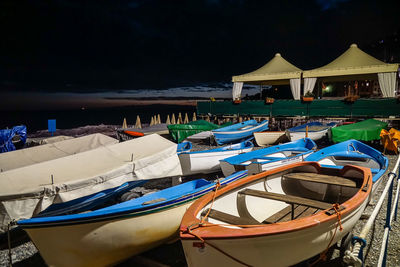 Boats moored at harbor against sky