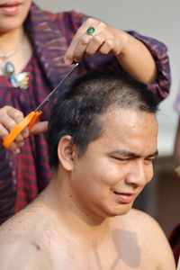 Woman cutting hair of man during ordination