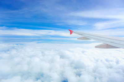 Airplane flying over cloudscape against sky