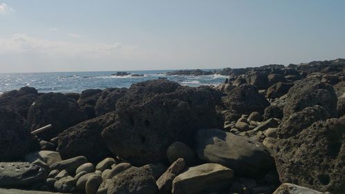 Rocks on beach against sky