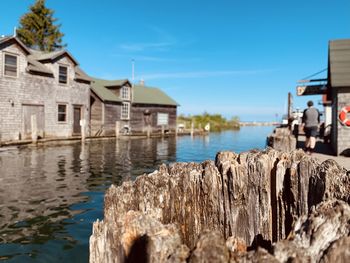Houses by sea against clear sky