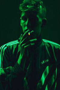 Portrait of young man smoking at night