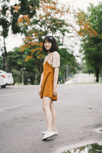 Young woman standing on road in city