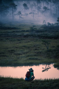 Scenic view of misty bog at dawn with photographer looking on