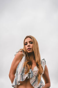 Portrait of a beautiful young woman standing against white background