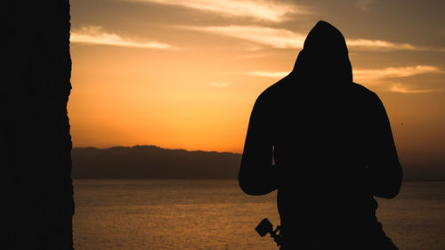 Silhouette of man standing against sky during sunset