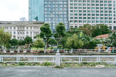 Fountain by building in city against sky