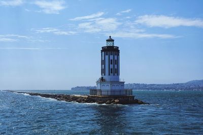 Lighthouse near coastline with rock pathway