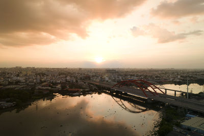 High angle view of river by buildings against sky during sunset