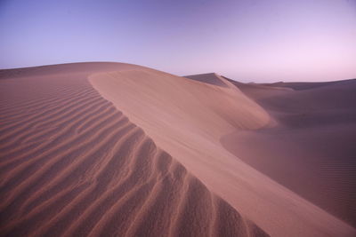 Scenic view of sand dunes at desert against sky