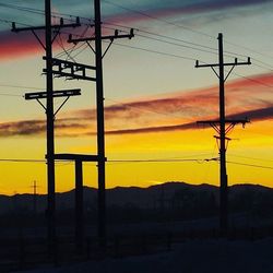 Electricity pylon against sky at sunset