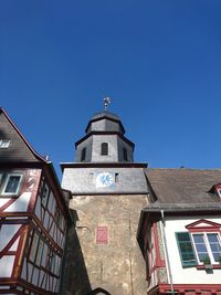 Low angle view of bell tower against clear blue sky