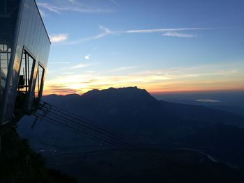 Overhead cable car station against mountains during sunset