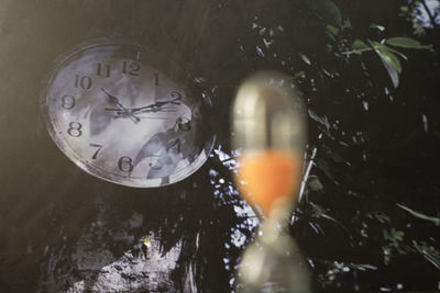 Close-up of wet glass against lake