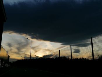 Silhouette street against sky during sunset