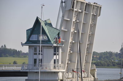 Built structure by river against sky