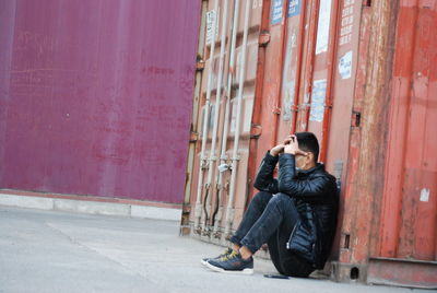 Side view of man sitting on street