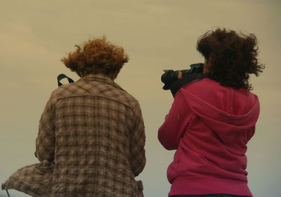 Rear view of photographers against sky