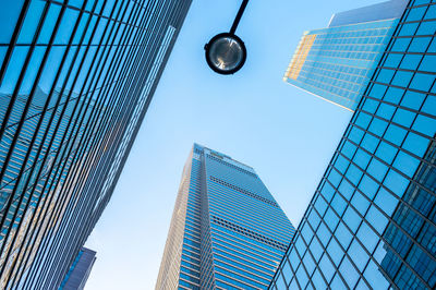 Low angle view of modern buildings against blue sky