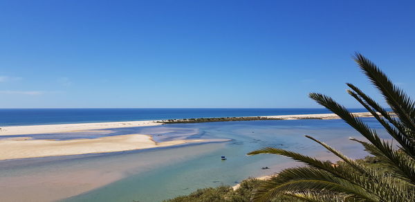 Scenic view of beach against blue sky