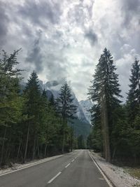 Road amidst trees against sky