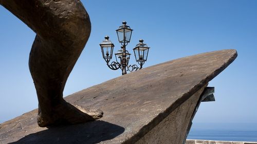 Low angle view of rusty metal against clear blue sky