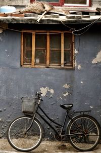 Bicycle parked by abandoned building