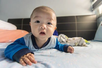 Portrait of cute baby lying on bed