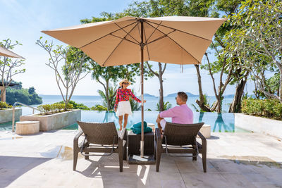 Rear view of people sitting on chair at table