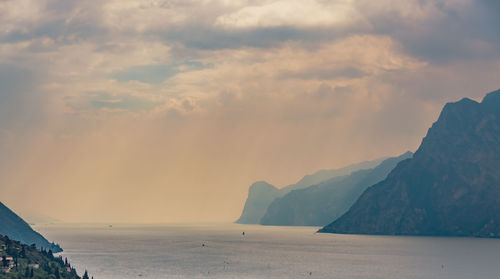 Scenic view of sea and mountains against sky during sunset