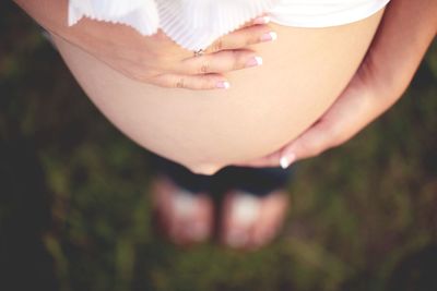 Midsection of woman touching grass