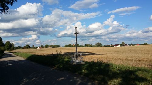 Road amidst field against sky