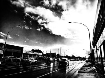 Cars on street in city against sky