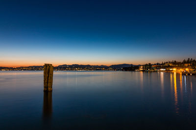 Scenic view of sea against clear blue sky at dusk